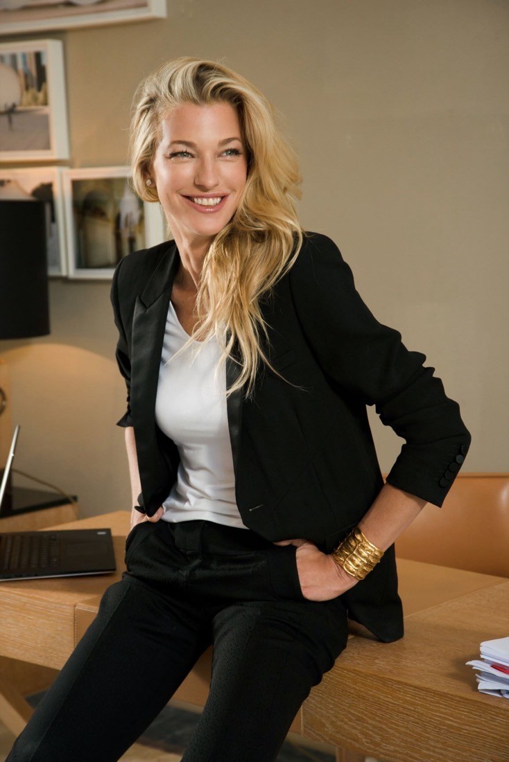 Nicole Brachetti Peretti, arts patron and investor, relaxed in a black blazer while leaning on a desk