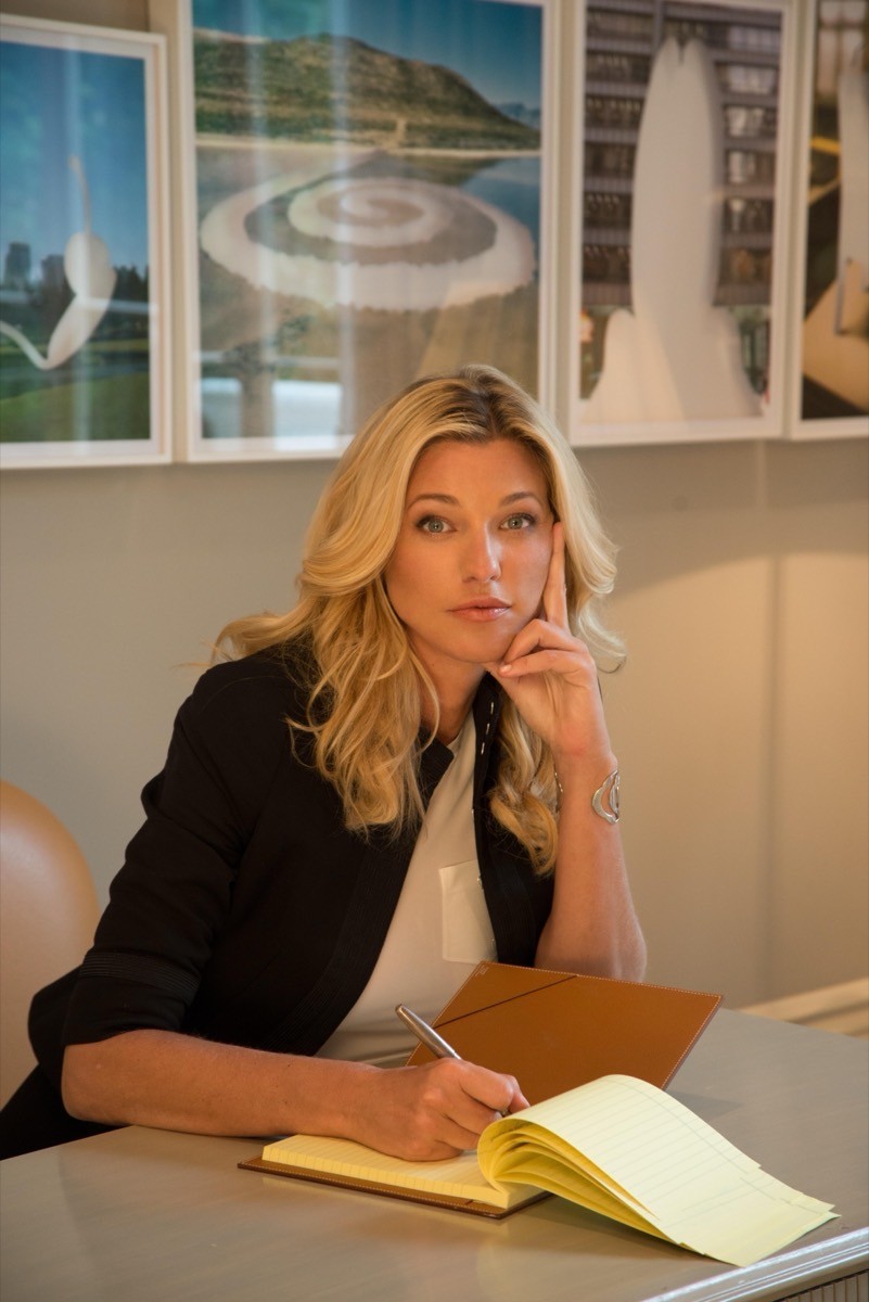 Nicole Brachetti Peretti, entrepreneur and arts patron, writing in a notebook at a lamp-lit desk